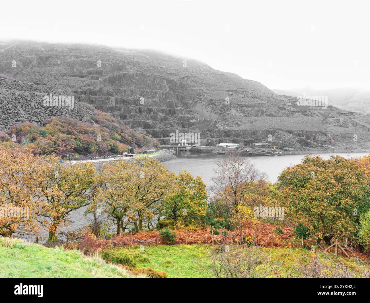 Centrale elettrica in fondo alle cave di ardesia sul bacino idrico di Llyn Peris ai piedi del passo di Llanberis, Galles, in una nuvolosa giornata autunnale. Foto Stock