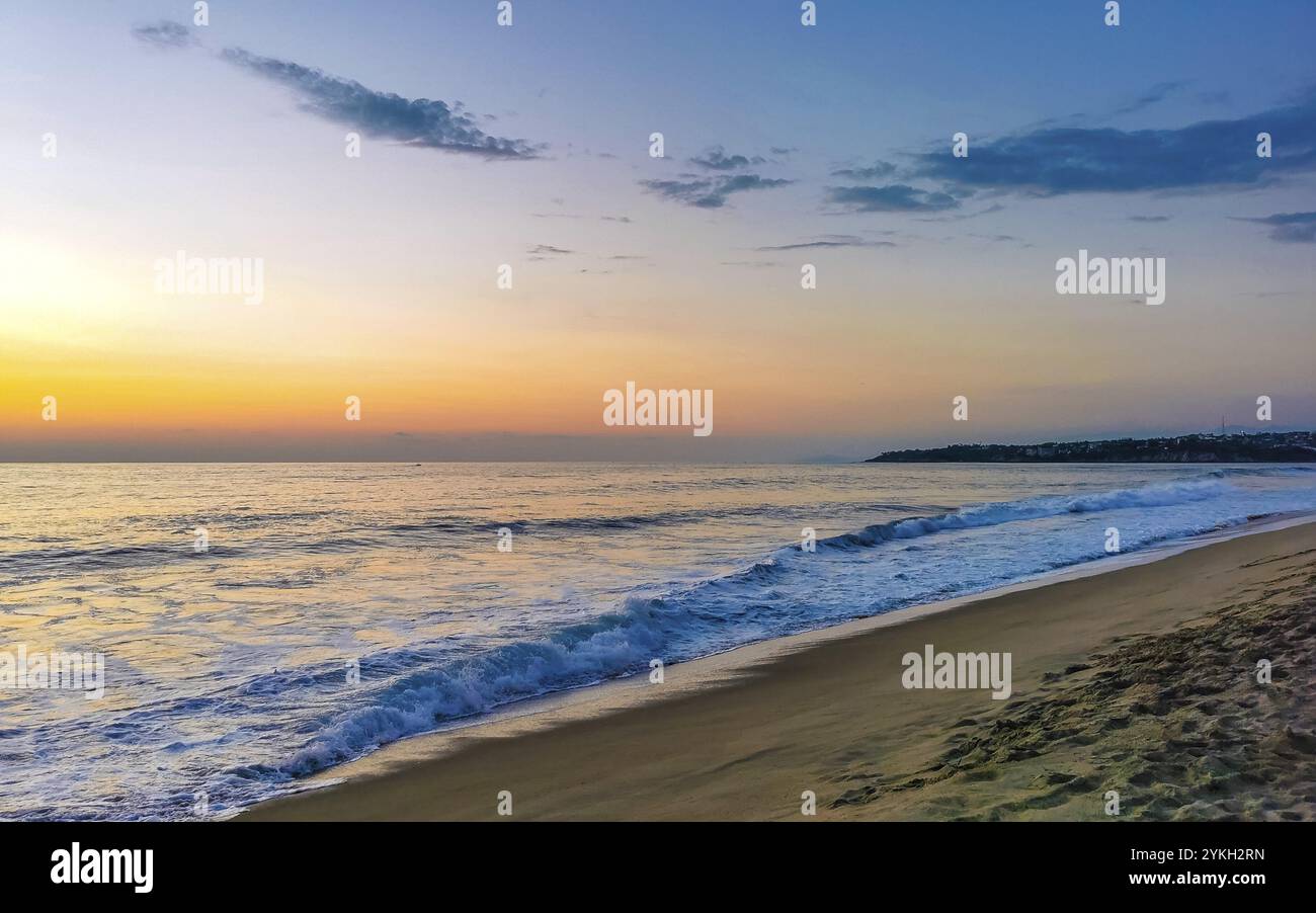 Bellissimo tramonto colorato e dorato in giallo arancio rosso sulla spiaggia e grande enorme panorama onda surfista nella natura tropicale a Zicatela Puerto es Foto Stock