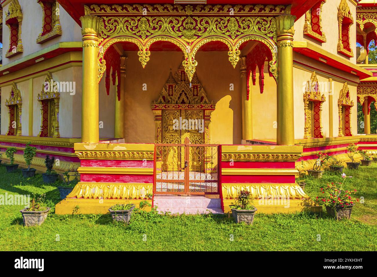 Porta d'ingresso all'interno del tempio buddista Wat Phol Phao in oro e rosso, i migliori templi incredibili di Luang Prabang Laos Foto Stock