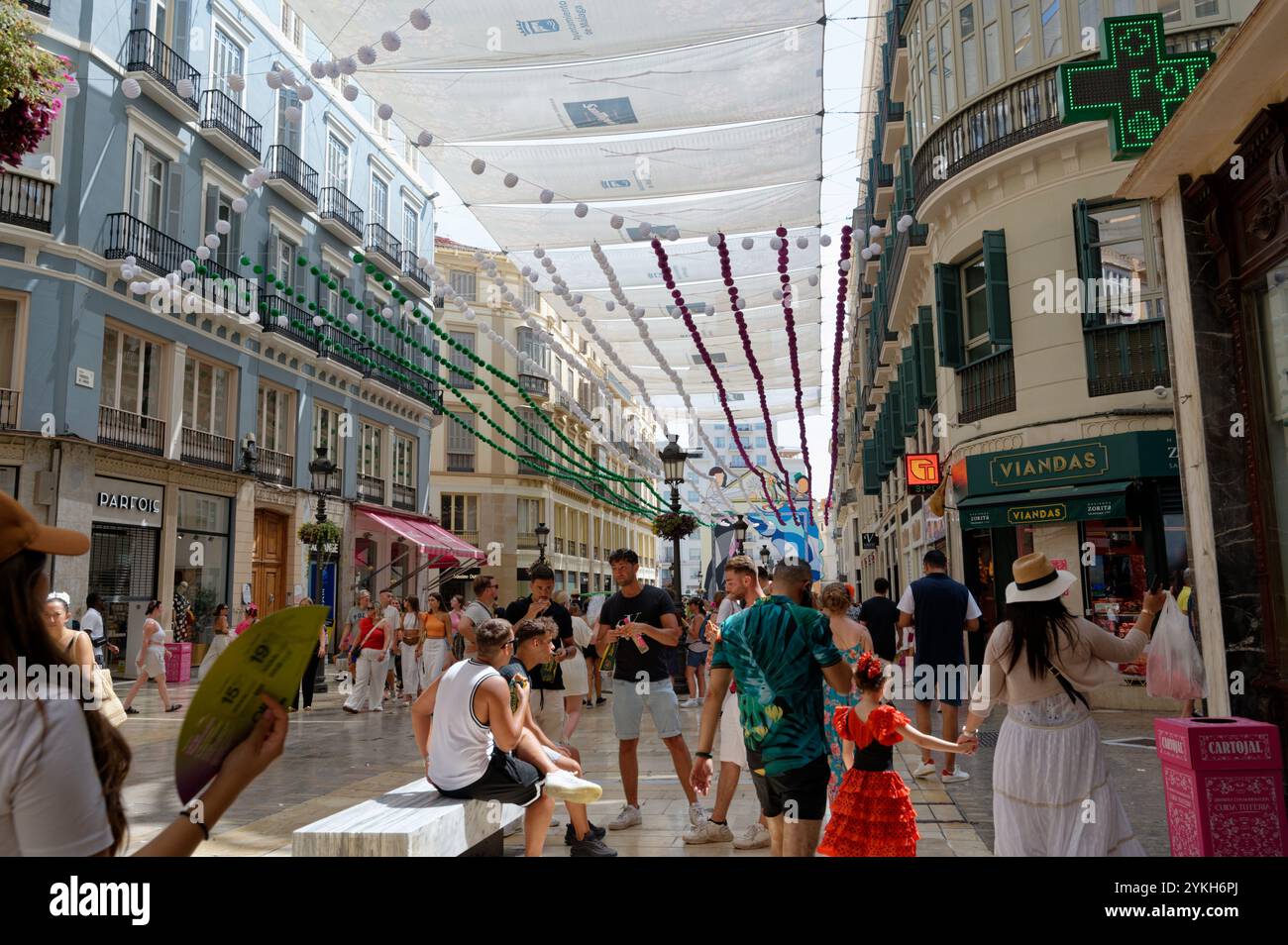 Decorata Calle Larios, si anima durante la Fiera di agosto, piena di visitatori festivi e di fascino andaluso Foto Stock