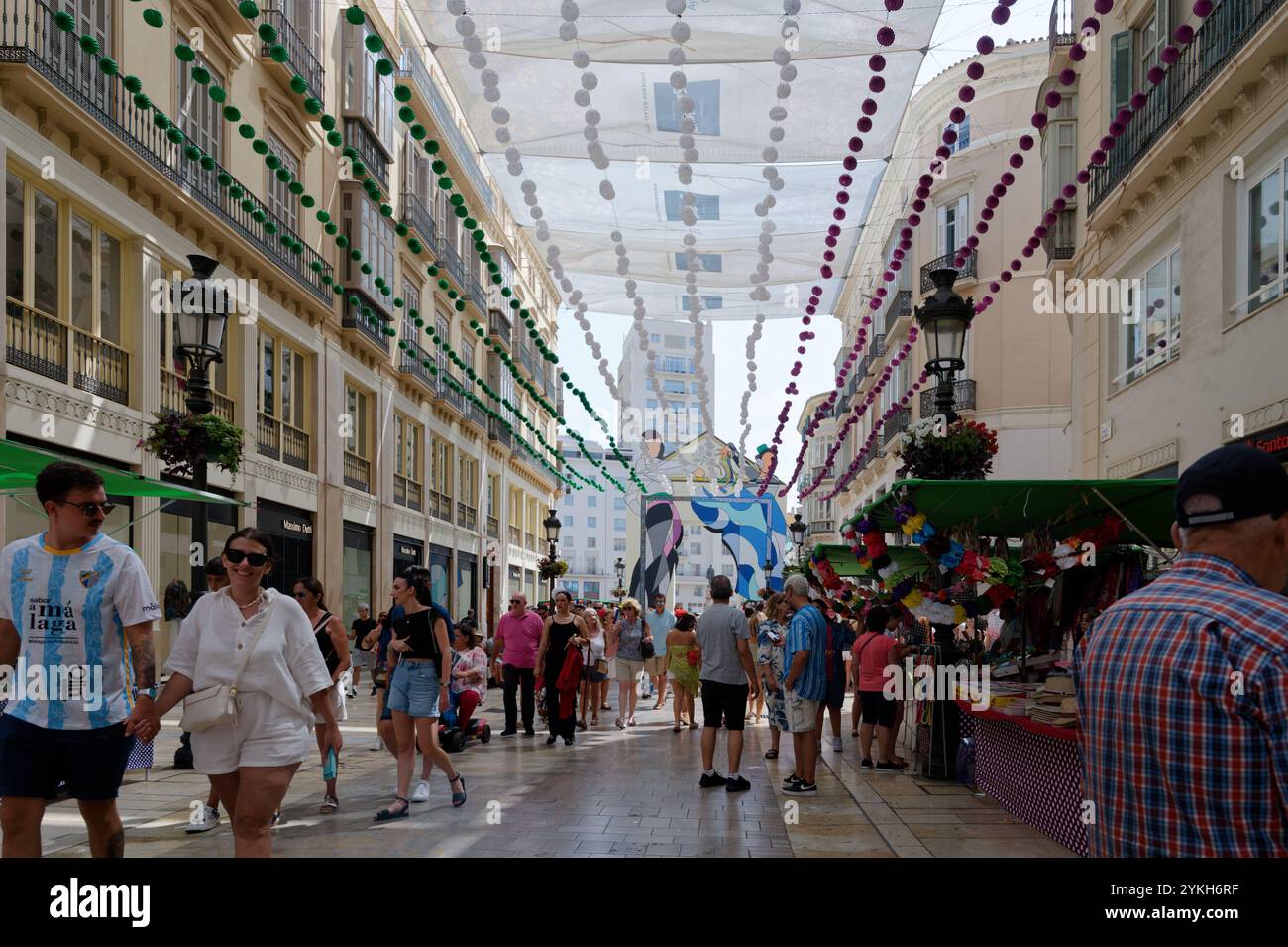 Festosa Calle Larios, adornata con decorazioni colorate e piena di visitatori durante la vibrante Fiera di agosto Foto Stock