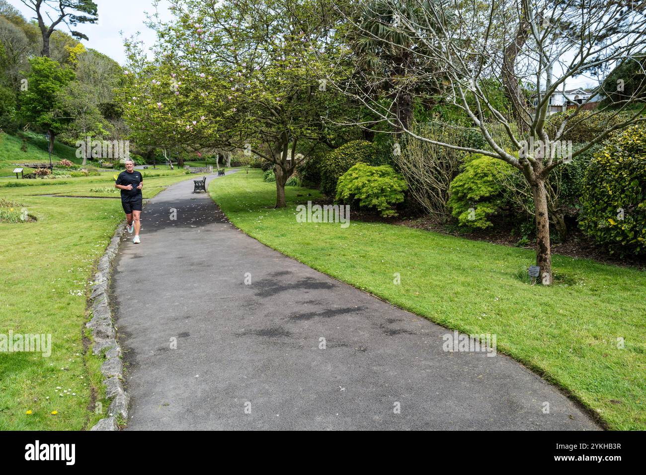 Un uomo maschio che corre attraverso i pluripremiati Trenance Gardens a Newquay, in Cornovaglia, nel Regno Unito. Foto Stock
