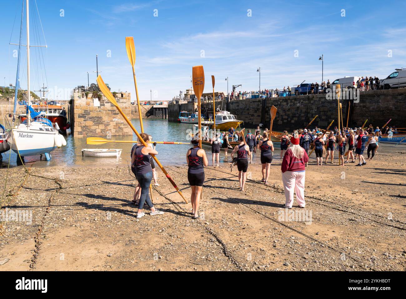 Gli equipaggi dei Pilot Gig che trasportano i loro remi in attesa di salire a bordo dei Pilot Gigs per l'evento femminile Newquay County Championships Cornish Pilot Gig Rowing a Newqu Foto Stock