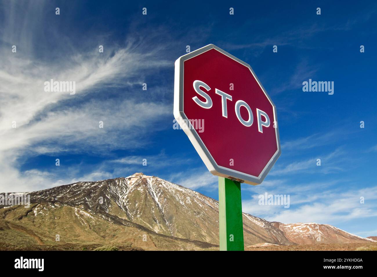 Cartello stradale DI "STOP" con la montagna dietro, che rappresenta un avvertimento concettuale simbolico per questioni ambientali come il riscaldamento globale e il cambiamento climatico Foto Stock