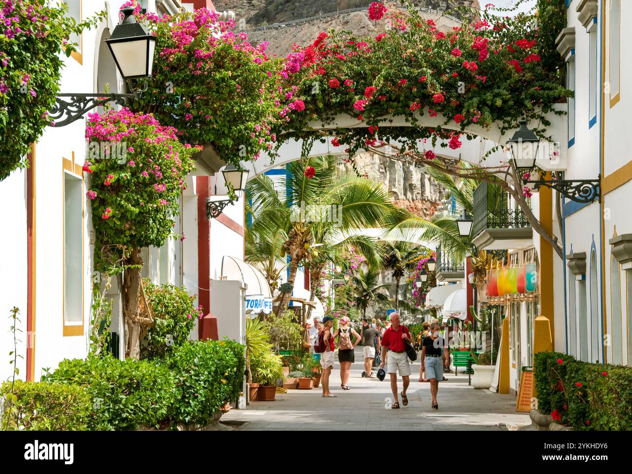 GRAN CANARIA Puerto de Mogan resort di lusso con turisti che passeggiano ed esplorano nella tranquilla zona pedonale di palme bouganville Gran Canaria Isole Canarie Spagna Foto Stock