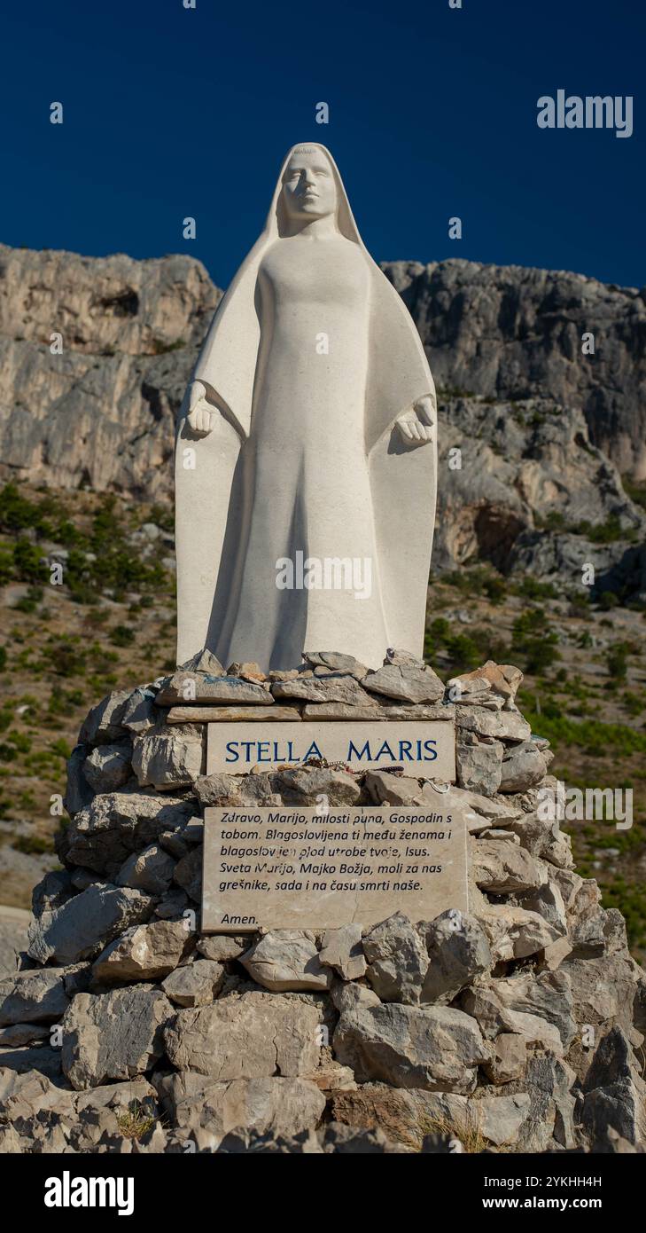 Statua della Vergine Maria sulle montagne croate, con una targa di preghiera "Ave Maria" circondata dalla natura. Foto Stock