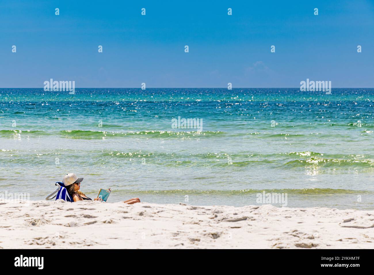 donna seduta sulla spiaggia al mare Foto Stock