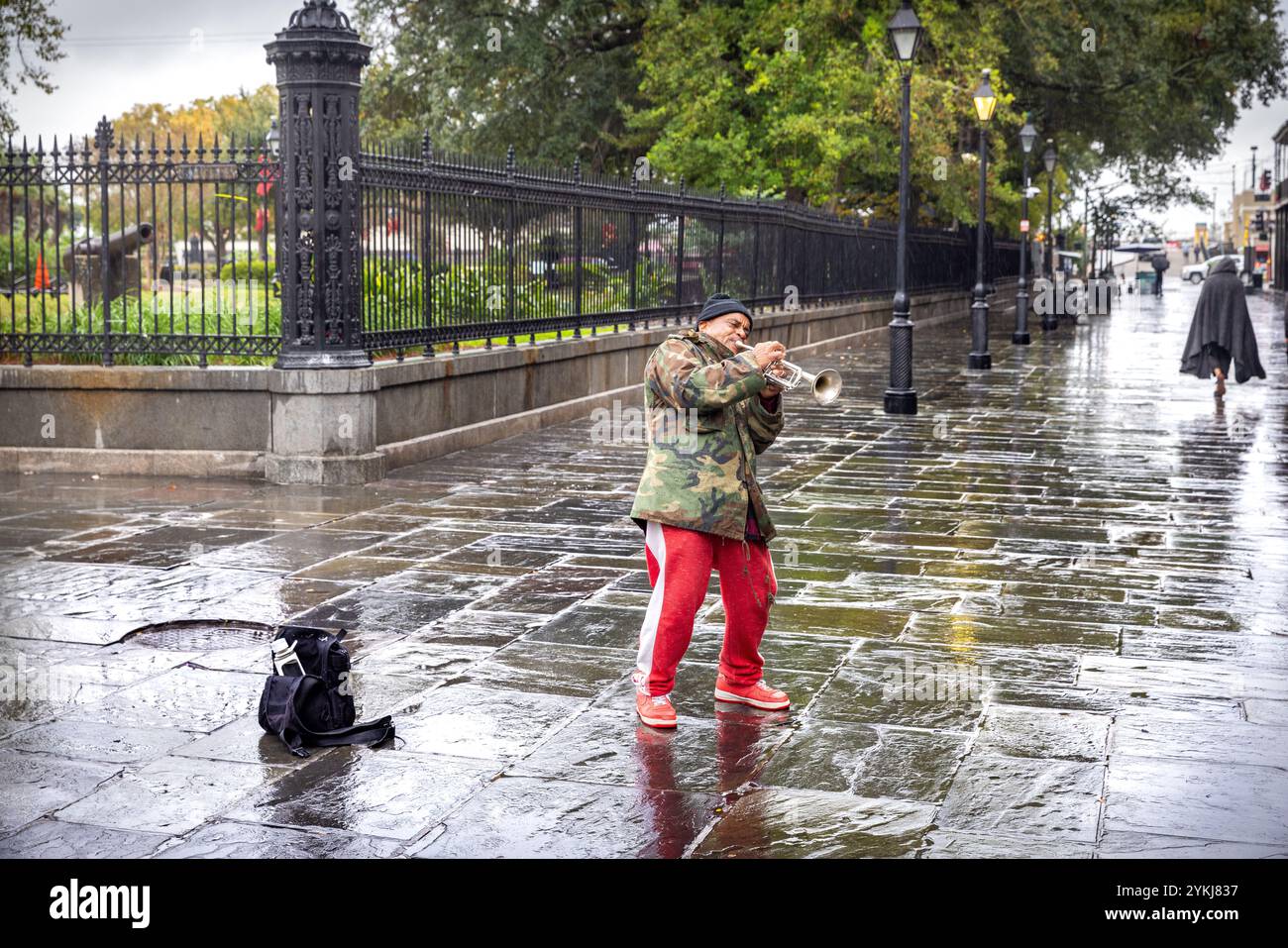 Un trombettista si esibisce sotto la pioggia in St. Peter St., accanto a Jackson Square, nel quartiere francese di New Orleans, Louisiana. Foto Stock