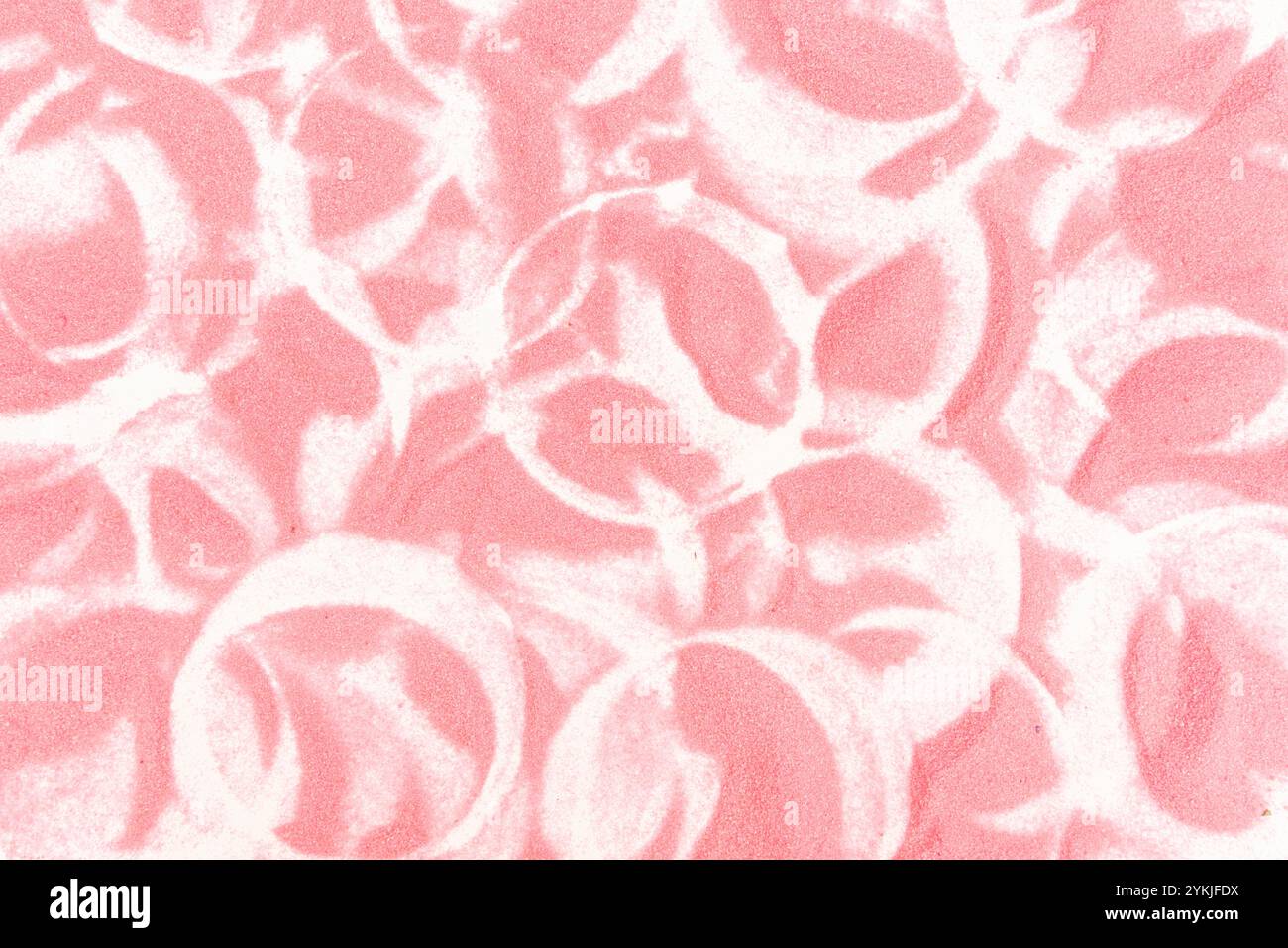 Sabbia rosa con tracce circolari su sfondo di carta bianca. Foto Stock