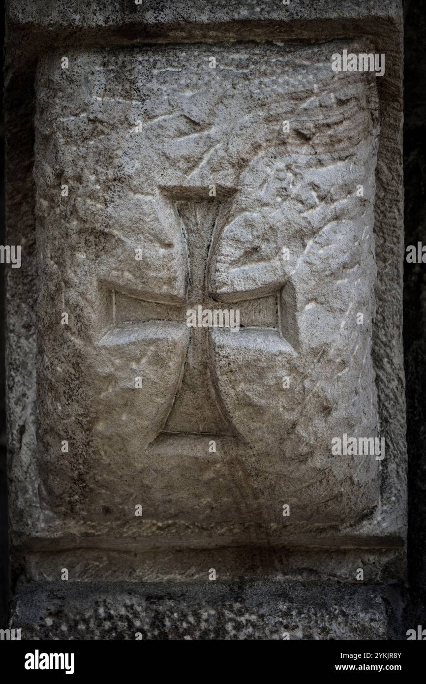 Croce templare, intaglio romanico, sulla Chiesa di San Cipriano de Bolmir, tempio romanico del XII secolo, villaggio di Bolmir, Campoo de Enmedio, Cantabria, Spagna. Foto Stock