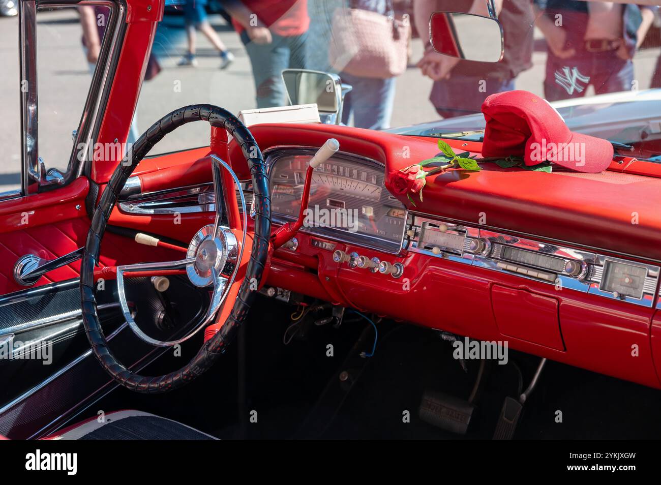 Gli interni di un'auto rossa sono caratterizzati da eleganti elementi vintage e colori brillanti. I partecipanti ammireranno lo splendido veicolo durante un vivace spettacolo di auto locale Foto Stock