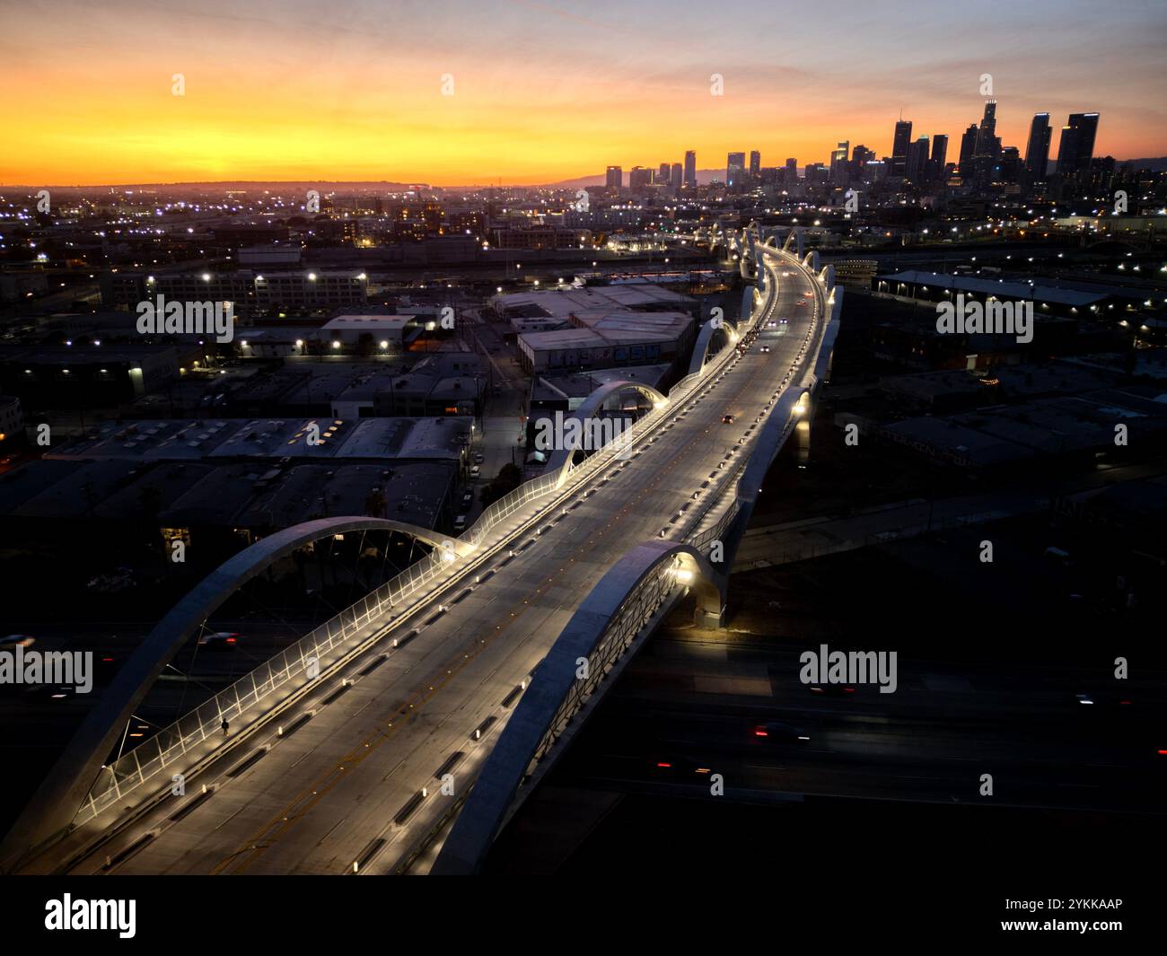 Nastro luminoso dell'autostrada mentre cala la notte sugli archi del viadotto della 6a strada nel centro di Los Angeles al crepuscolo Foto Stock