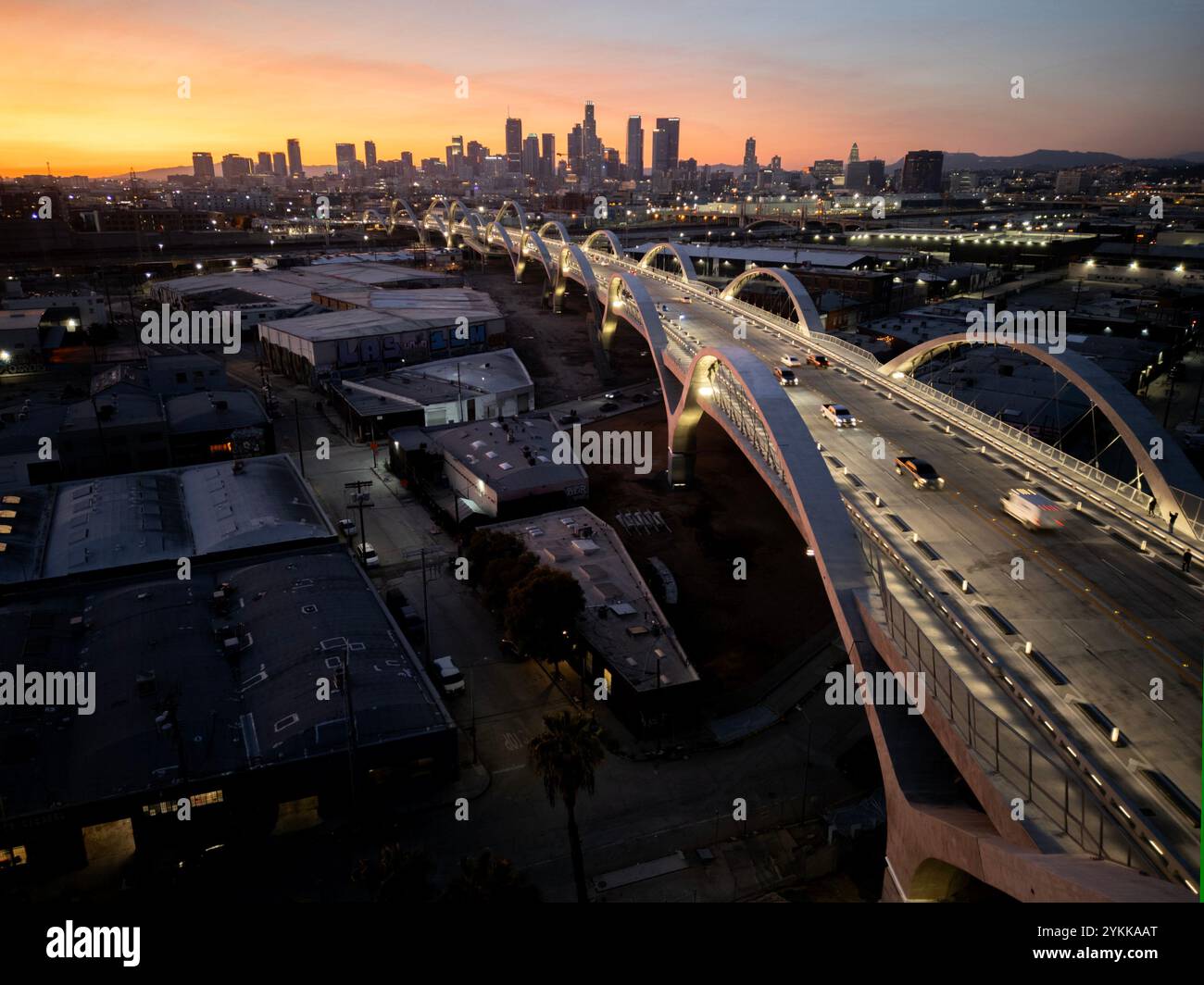 Nastro luminoso dell'autostrada mentre cala la notte sugli archi del viadotto della 6a strada nel centro di Los Angeles al crepuscolo Foto Stock