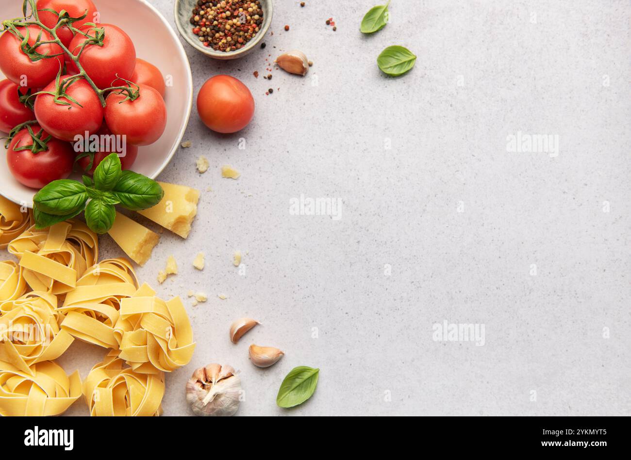 Ingredienti freschi disposti su uno sfondo testurizzato, formano una cornice per la creatività culinaria e l'ispirazione della cucina italiana Foto Stock