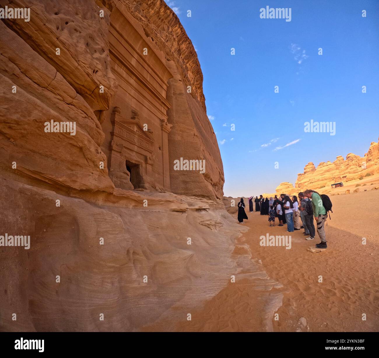 Turisti che visitano la tomba 45 a Jabal AlBanat (Qasr AlBint), il sito archeologico di Hegra (al-Hijr / Madā ͐ in Ṣāliḥ), nel deserto vicino ad al Ula, in Arabia Saudita Foto Stock