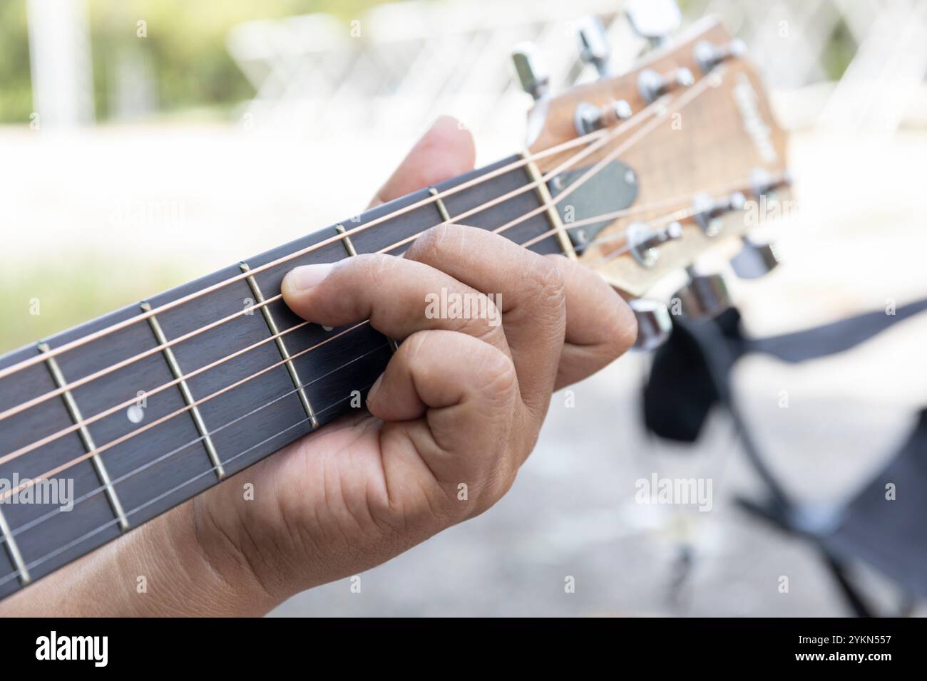 le mani del chitarrista si muovono con maestria e passione, mentre le dita rimbalzano le corde acustiche, tessendo le note in una melodia che porta calore e armonia Foto Stock
