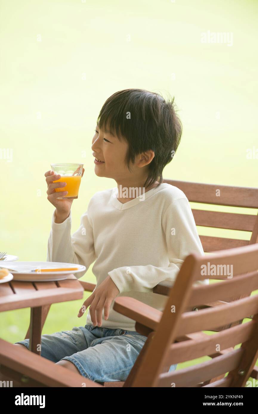 Ragazzo che mangia nel parco Foto Stock