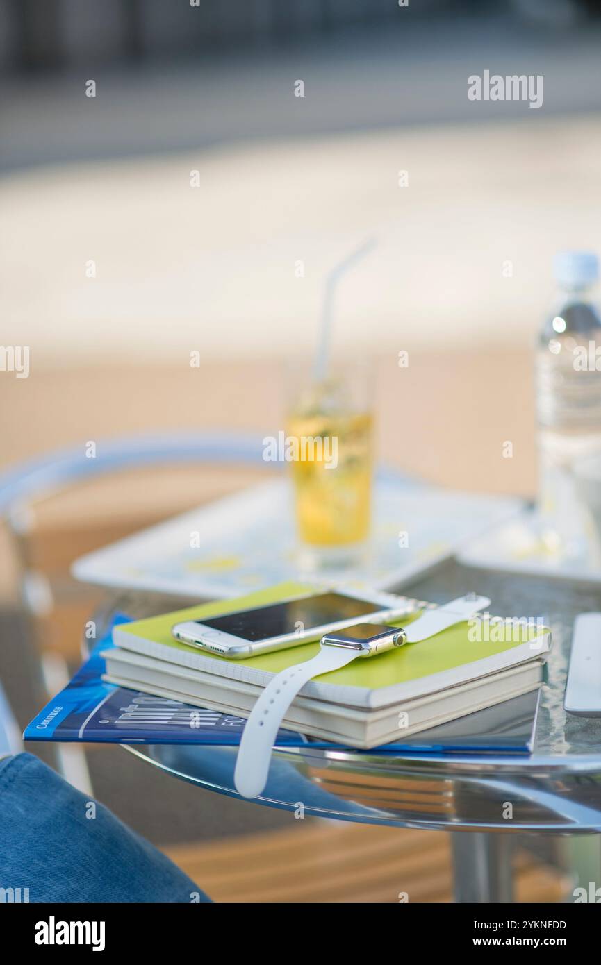 Manuale, orologio indossabile e smartphone sul tavolo Foto Stock