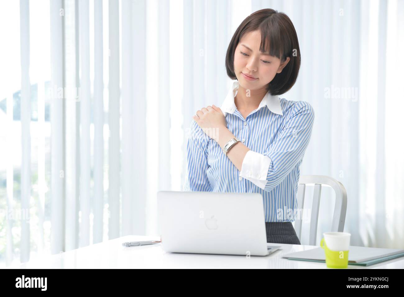 Lavoratore in ufficio con spalle rigide dal lavoro sulla scrivania Foto Stock