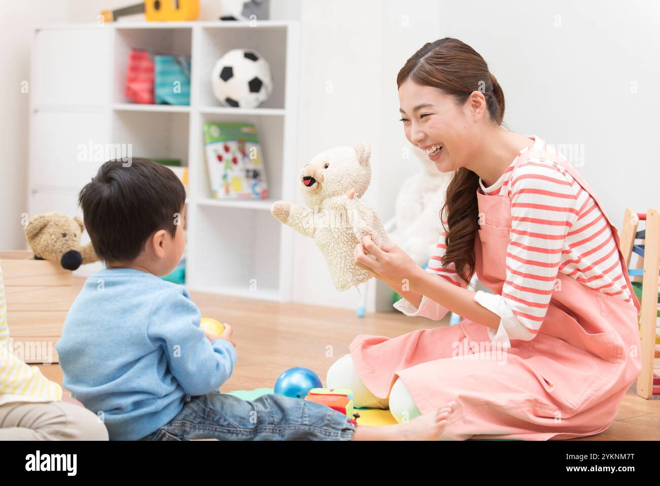 Ragazzo che gioca con una donna che lavora per l'infanzia Foto Stock