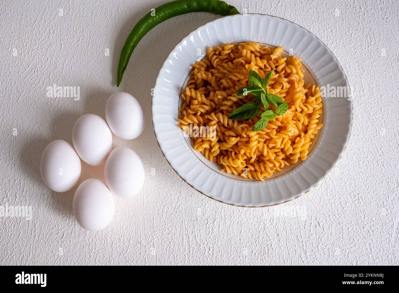 pasta a spirale con salsa di pomodoro cremosa su un piatto bianco al rallentatore Foto Stock