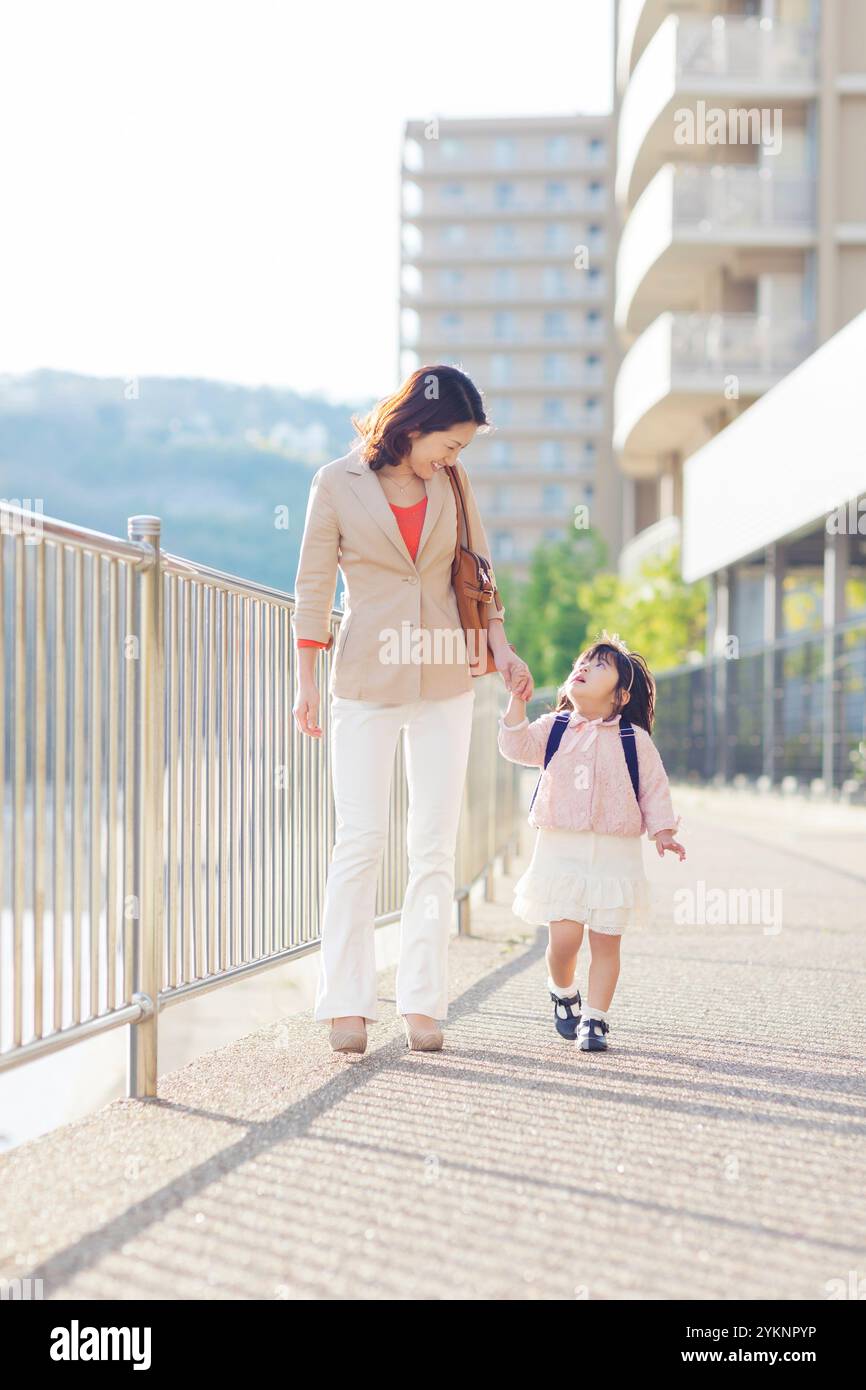 Madre e figlia camminando mano nella mano Foto Stock