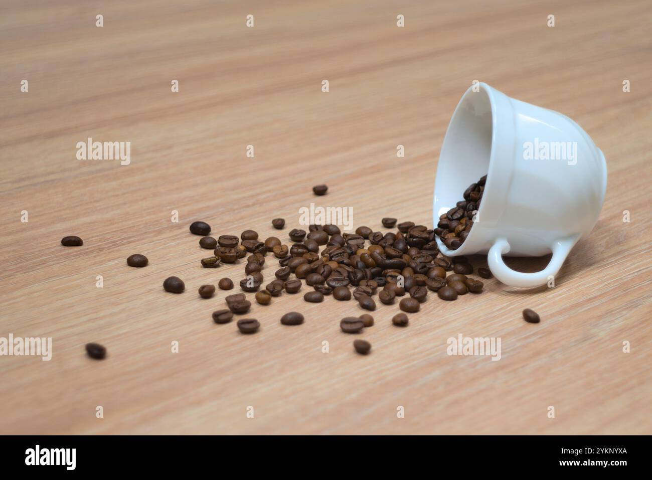 Tazza di caffè rovesciata con chicchi di caffè Foto Stock