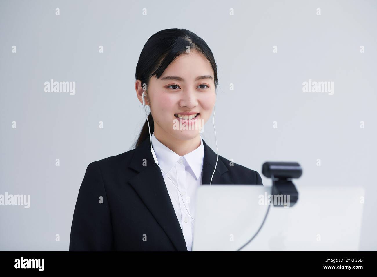 Giovane donna in tuta che parla con la fotocamera davanti al laptop Foto Stock