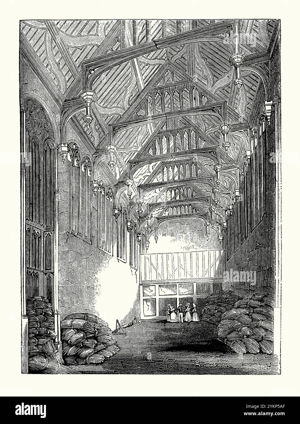 Una vecchia incisione dell'interno della Great Hall a Eltham Palace, Eltham, Greenwich, se Londra, Kent, Inghilterra, Regno Unito c.1700, quando gran parte della terra circostante fu affittata e la sala utilizzata per immagazzinare il fieno, è tratta da un libro di storia vittoriana. Il palazzo originale fu dato a Edoardo II nel 1305 e utilizzato come residenza reale dal XIV al XVI secolo. Con la grande ricostruzione di Greenwich Palace, Eltham fu lasciata in uno stato fatiscente. La Great Hall vanta il terzo tetto a martelletto più grande d'Inghilterra. Foto Stock
