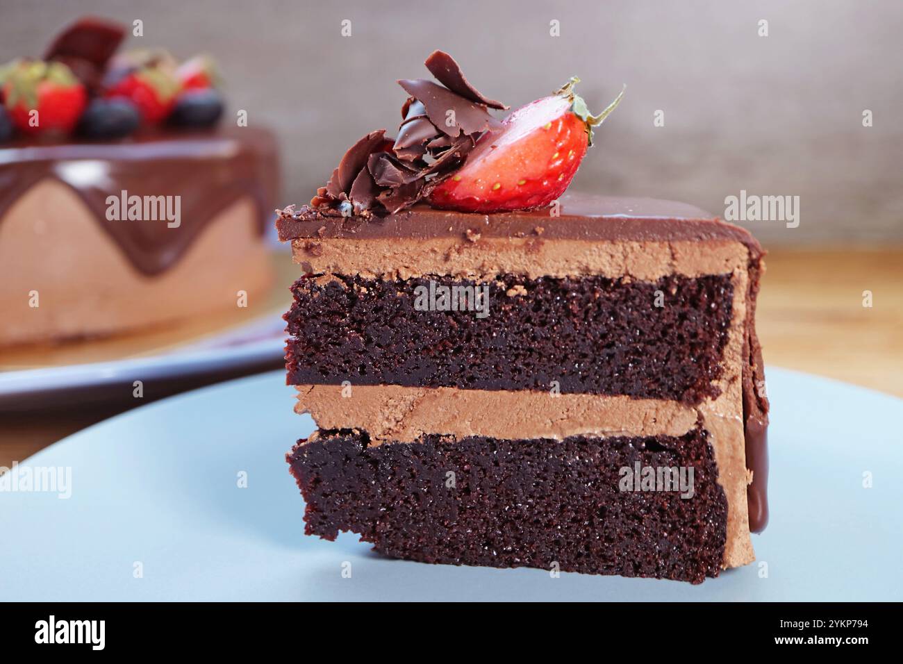Fetta di gustosa torta al cioccolato fondente con fragole fresche e mirtilli Foto Stock