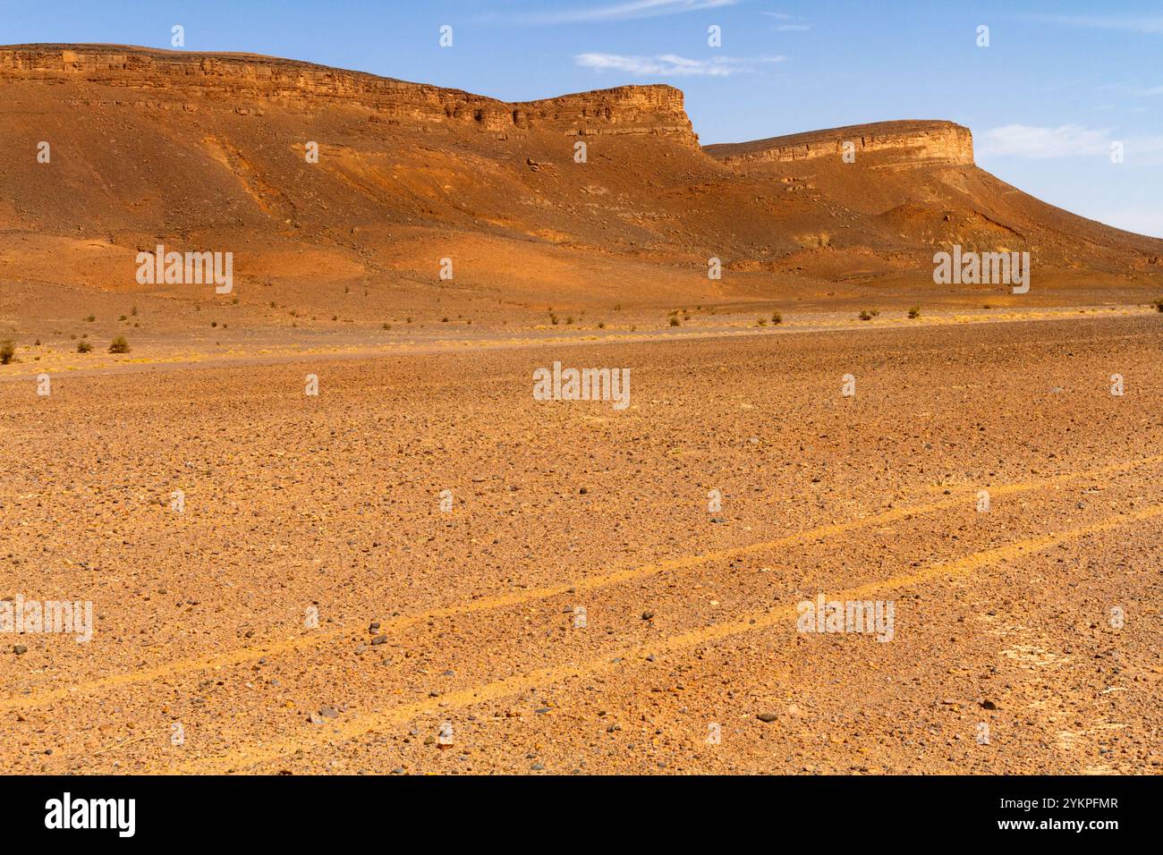 Deserto di pietra secca e montagna solitaria sullo sfondo. Marocco Foto Stock