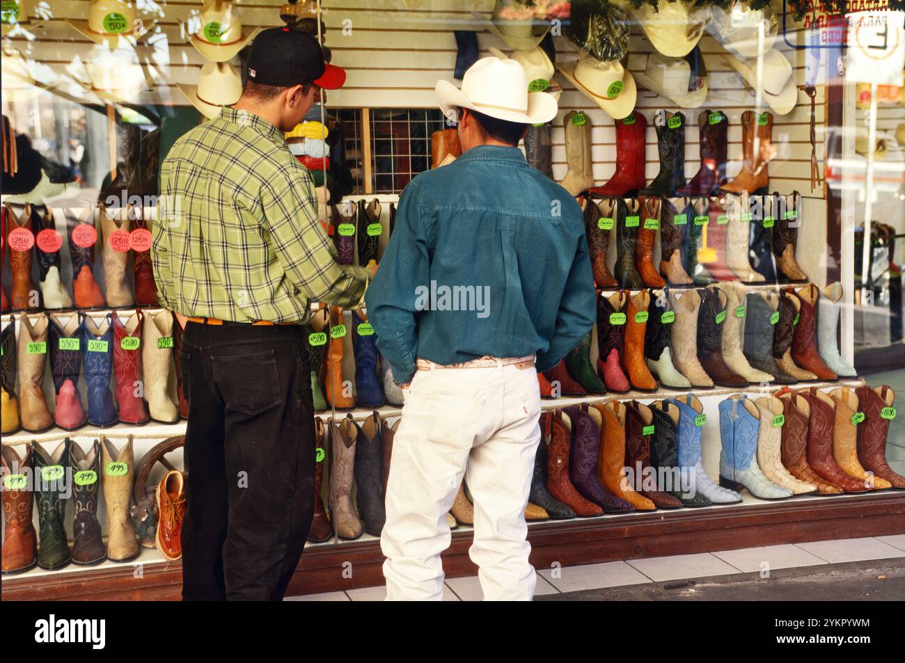 Gli uomini che guardano gli stivali da cowboy sono esposti a Calle Libertad, Ciudad de Chihuahua (città di Chihuahua), Stato di Chihuahua, Messico Foto Stock