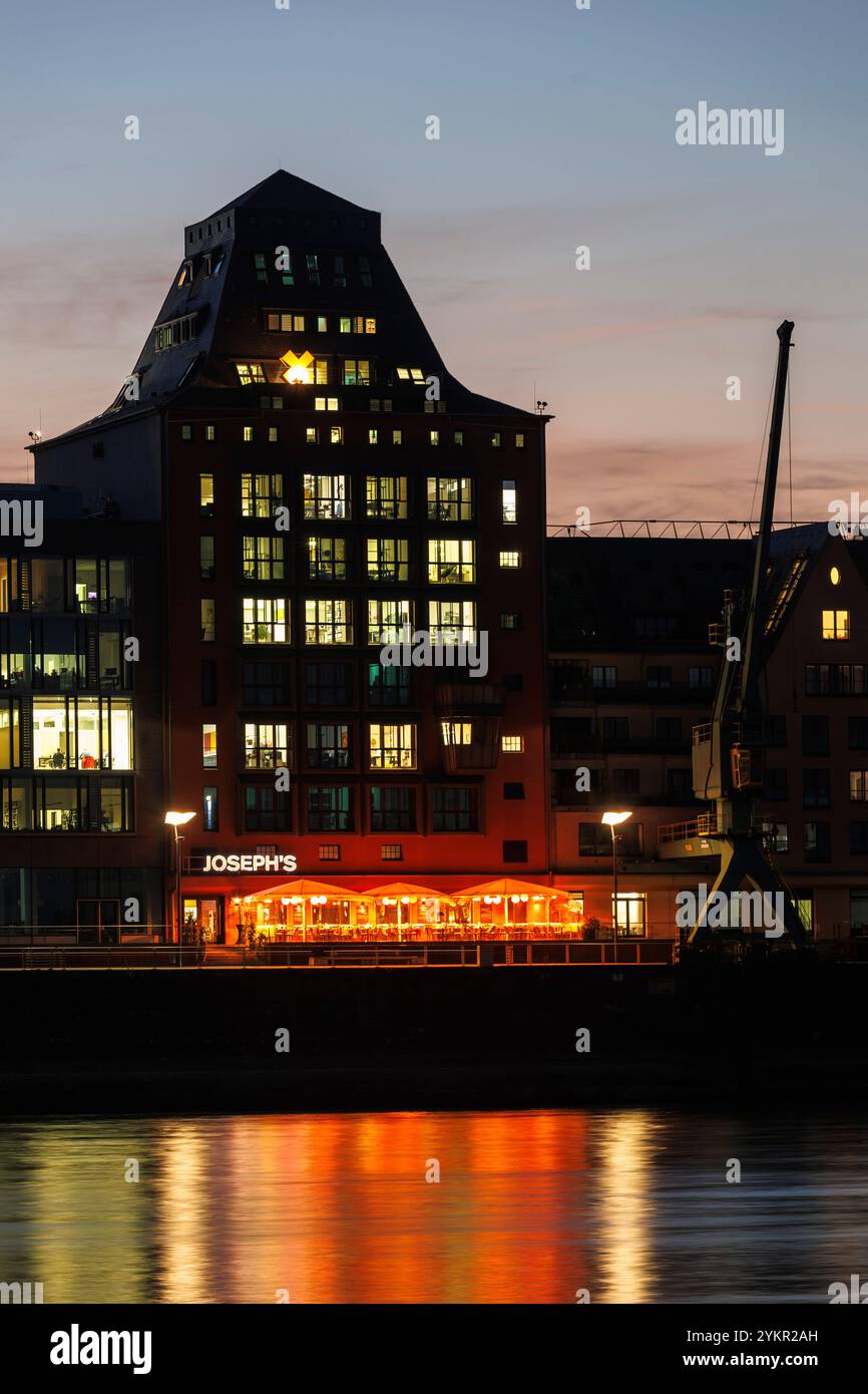 Vista sul fiume Reno fino all'edificio degli uffici Silo 23, un vecchio granaio al porto di Rheinau, ristorante Joseph's, Colonia, Germania. Blick ueber de Foto Stock