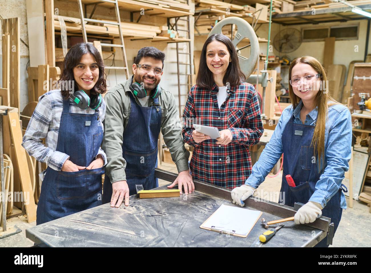 Un gruppo di lavoratori diversi, sia giovani che anziani, che lavorano insieme in un bosco. Dimostrano il lavoro di squadra, la collaborazione e lo sviluppo delle competenze Foto Stock