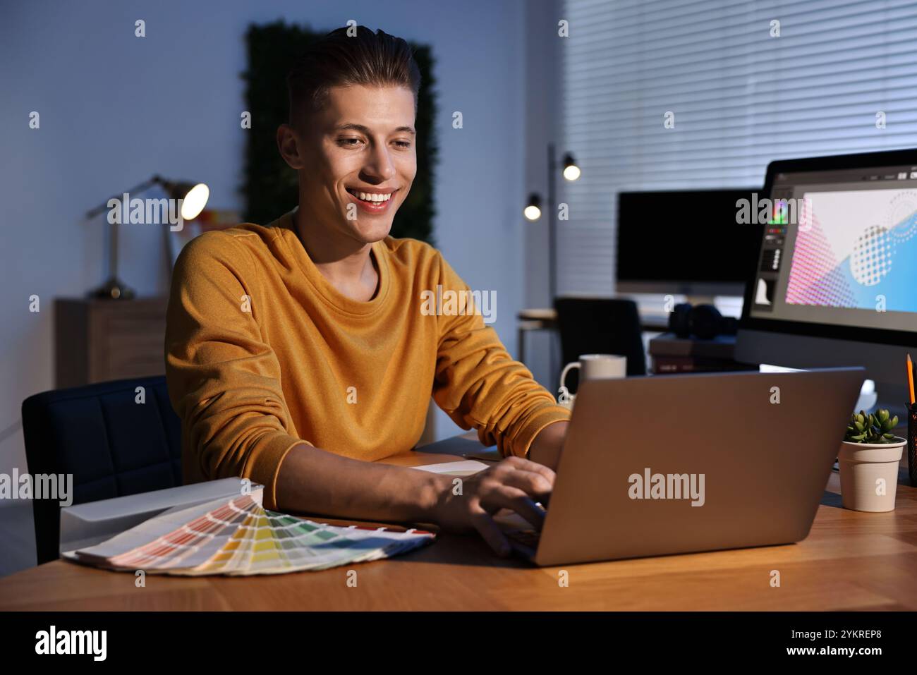 Designer che lavora su un notebook in interni di notte Foto Stock