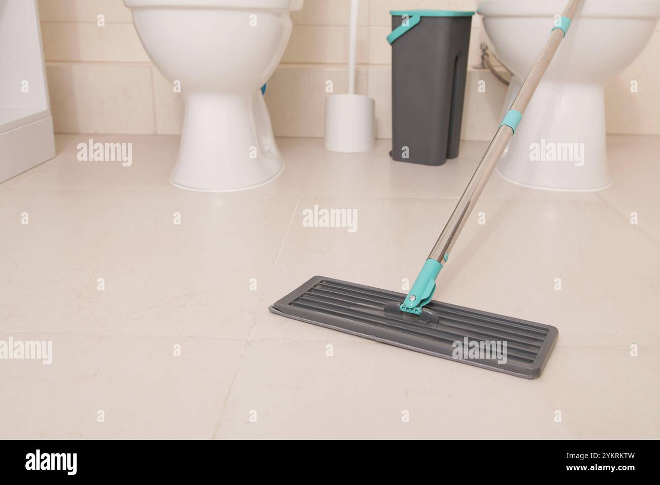 Pulizia del pavimento in bagno, WC. Primo piano del mocio. Superficie pulita pavimento piastrelle in ceramica grande . Copia spazio. Mock-up Foto Stock