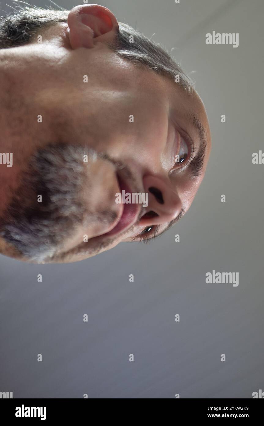 Primo piano con angolazione bassa di un uomo di 50 anni con capelli e barba grigi Foto Stock