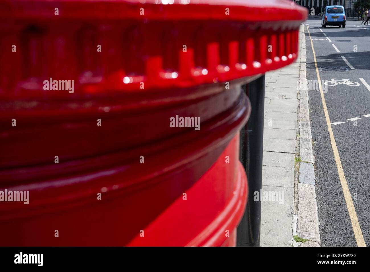 Casella delle lettere rossa, sfondo urbano con pista ciclabile e taxi di Londra azzurro, Bloomsbury, Central London, Inghilterra, Regno Unito, Europa Foto Stock