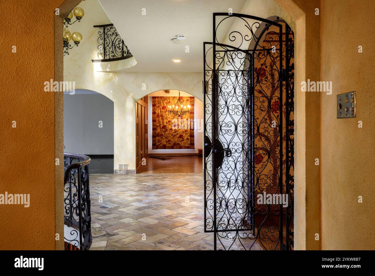 Cancelli in ferro battuto che guardano attraverso il foyer anteriore in una villa. Questa casa è stata demolita da allora. Foto Stock
