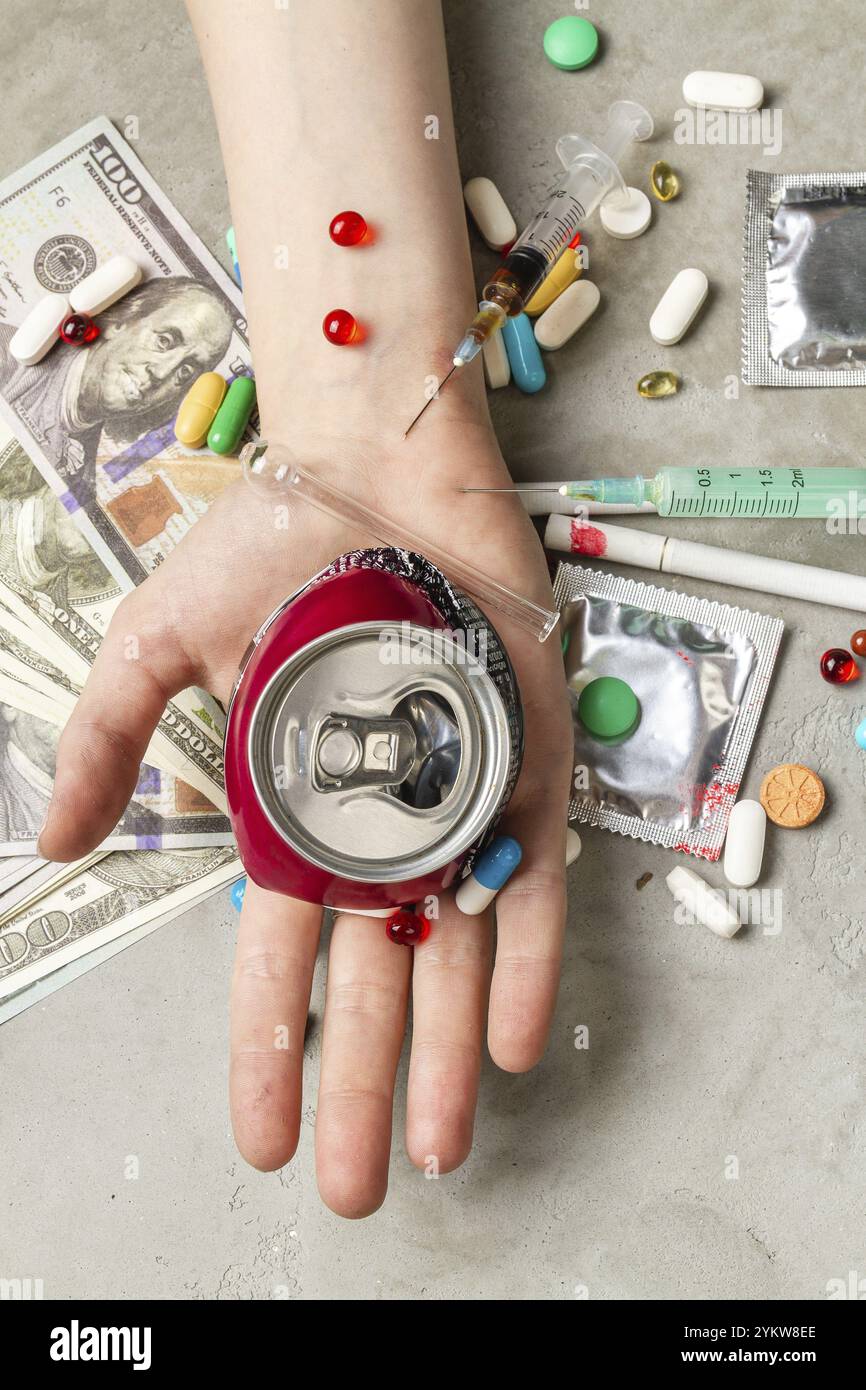 Vista dall'alto che regge una lattina di soda schiacciata. Concetto di tossicodipendenza Foto Stock