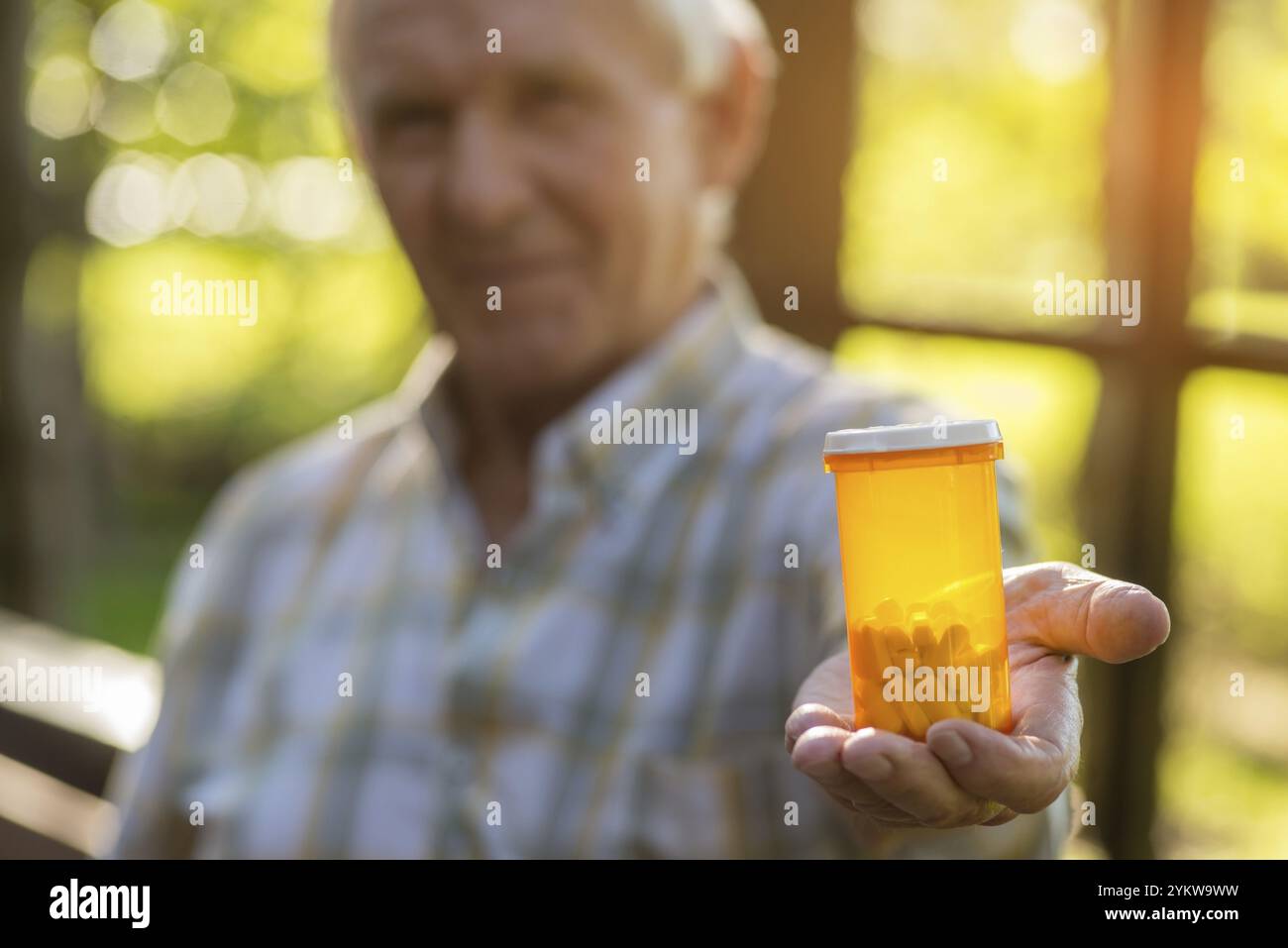 Bottiglia di pillole per mani maschio. Contenitore per medicinali di colore arancione. La miglior cura contro il dolore. La scienza aiuta a salvare la salute Foto Stock