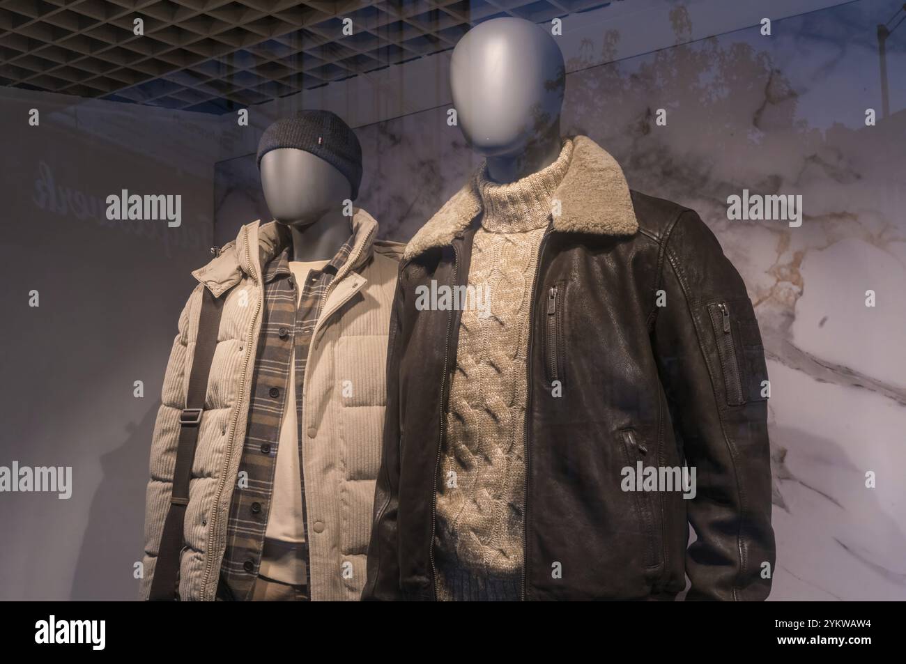 Due manichini espongono giacche invernali alla moda e un maglione caldo, che mostrano le tendenze attuali in un negozio al dettaglio Foto Stock