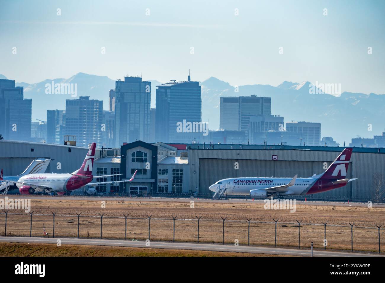 Calgary, Alberta Canada, ottobre 30 2024: Compagnia aerea Canada North Canadian con jet parcheggiati su un pendio che si affaccia sullo skyline del centro su una strada nebbiosa Foto Stock