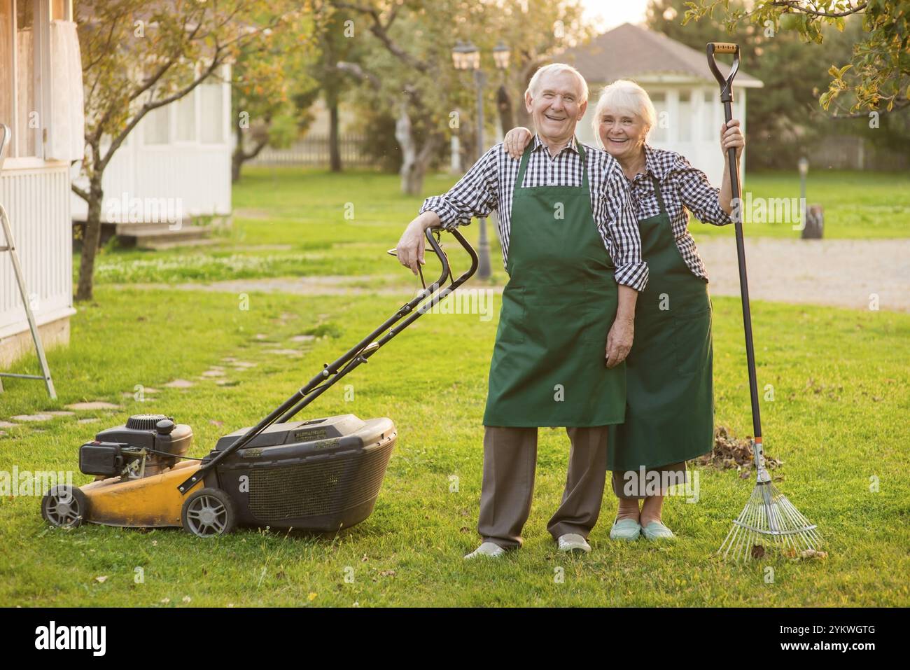 Un paio sorridente di giardinieri anziani. Gente felice all'aperto, estate. Lavori di manutenzione del giardino Foto Stock