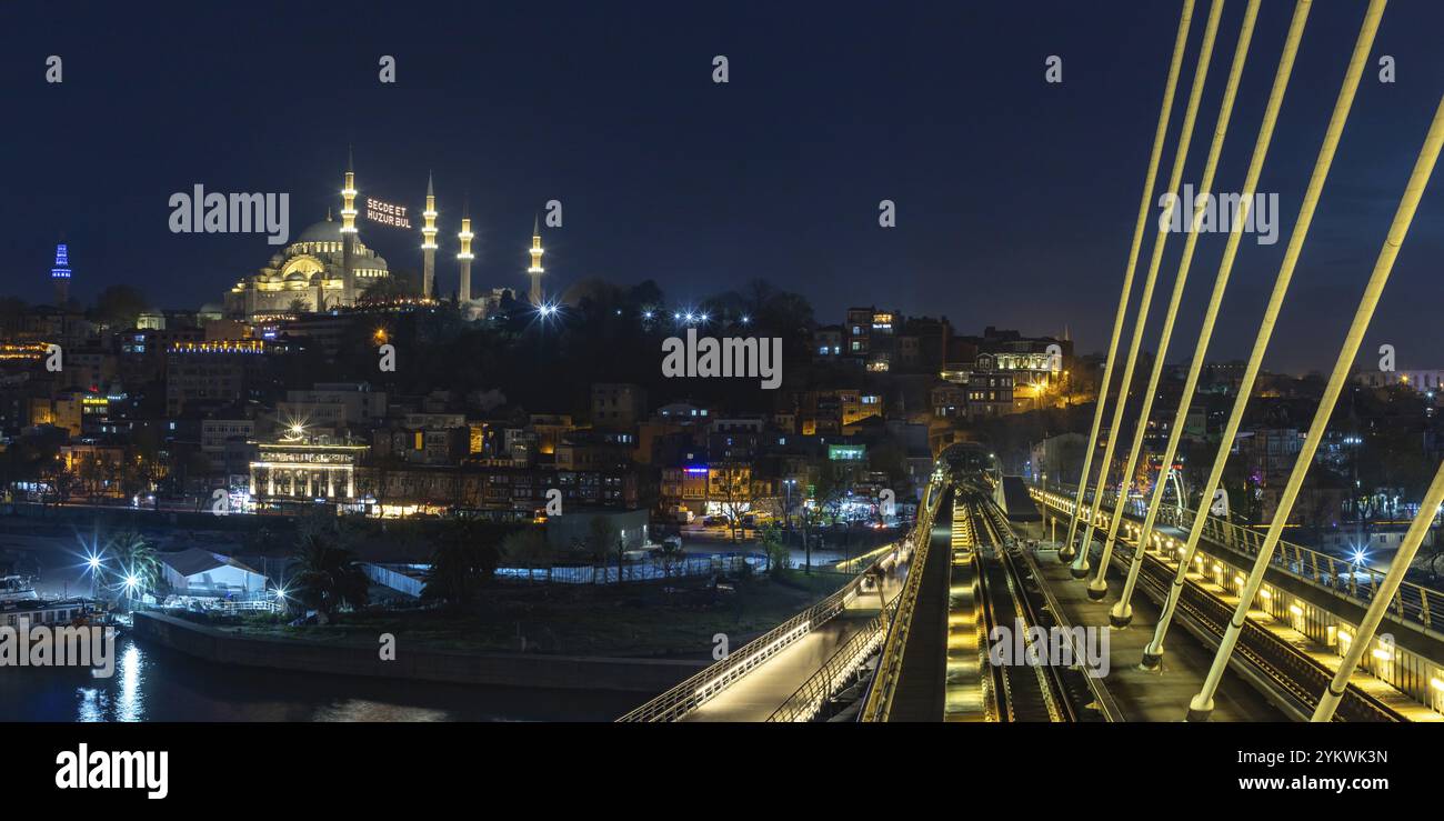 Una foto della Moschea Suleymaniye e del Ponte del Corno d'Oro di notte. Il cartello sulla moschea recita come Foto Stock