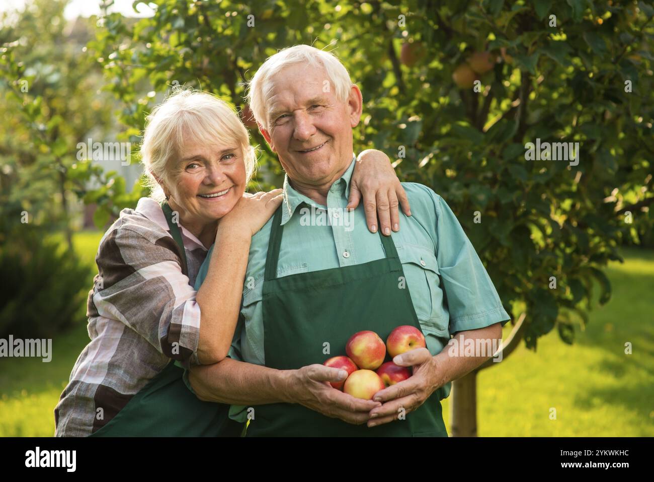 Coppia anziana con mele. Gente sorridente all'aperto. Consigli per il giardinaggio Foto Stock