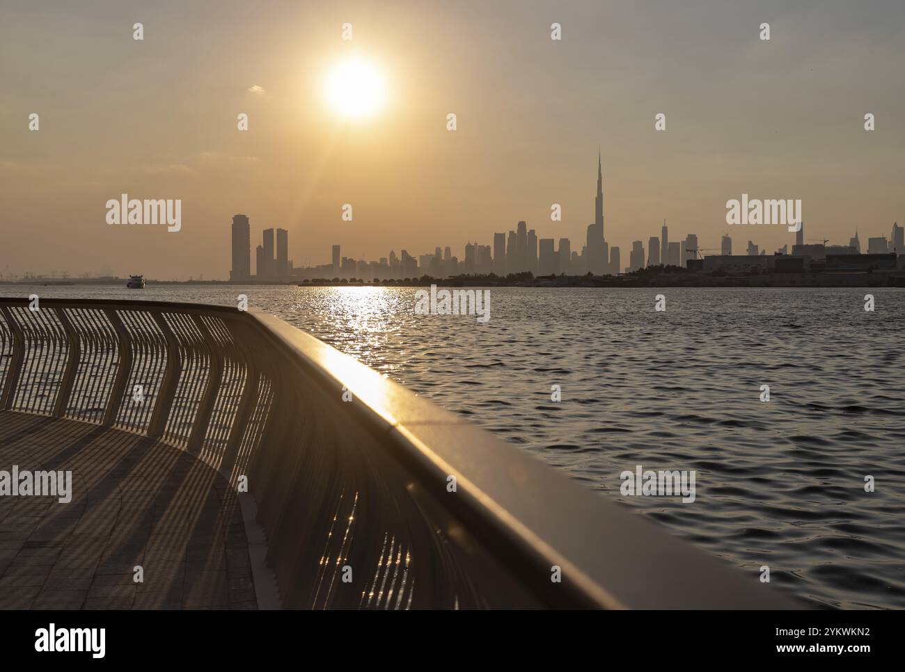 Una foto del centro di Dubai al tramonto, visto da lontano, con il Burj Khalifa che torreggia tutti gli alti edifici Foto Stock