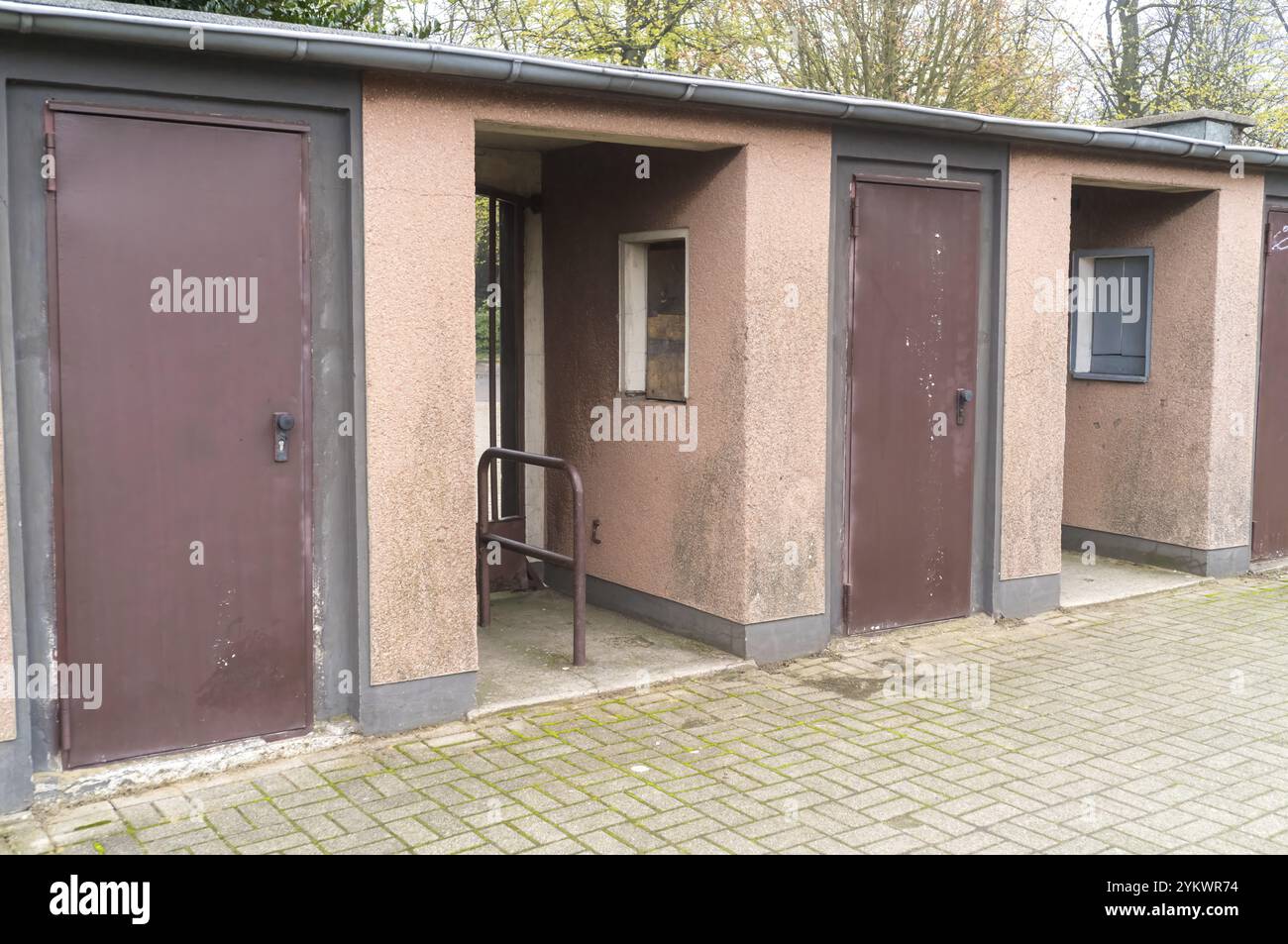 Le porte dei garage intemprate e le finestre a bordo evocano un senso di abbandono e degrado Foto Stock