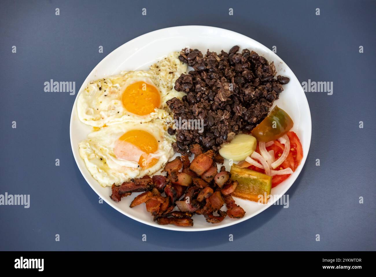 Cibo tradizionale brasiliano quotidiano, stufato di fagioli neri, pancetta, uova, insalata, sottaceti. Vero cibo rustico Foto Stock