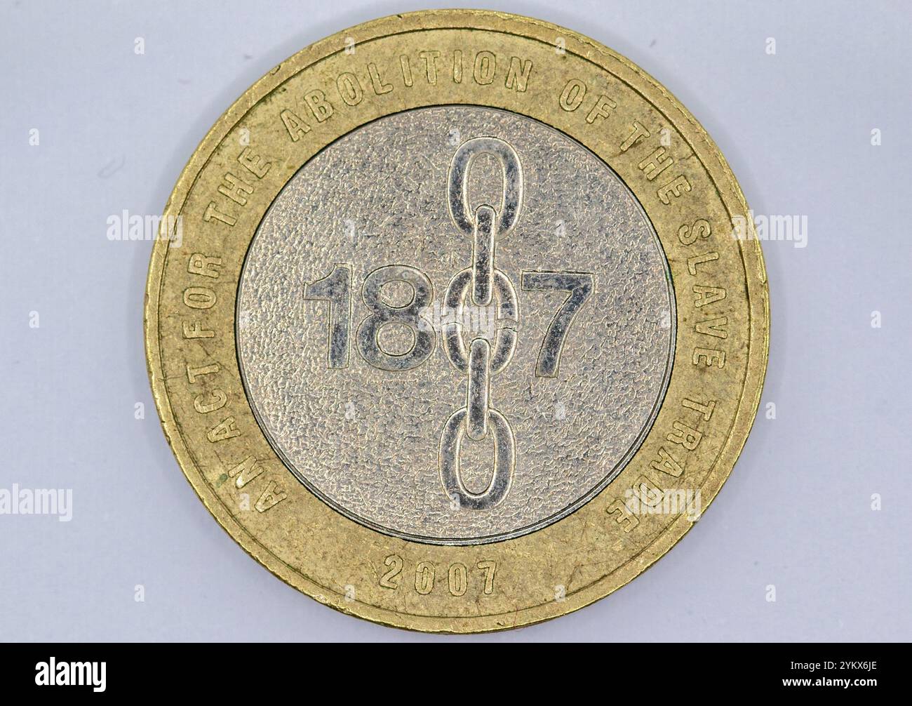 Una moneta commemorativa britannica del 2007, tonalità oro e argento, raffigura l'anno 1807 e le catene rotte, commemorando la legge per l'abolizione dello slavo Foto Stock